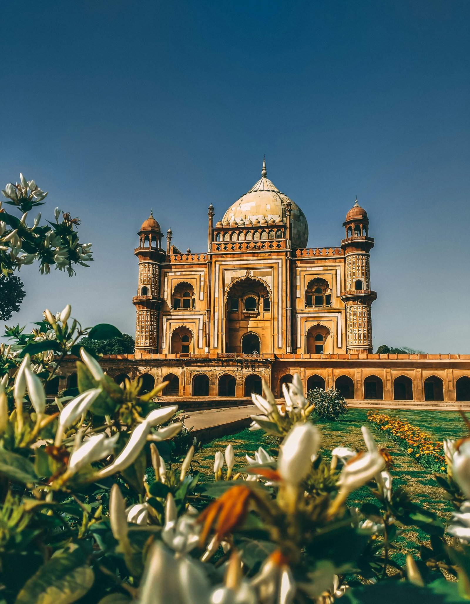 Majestic view of Safdarjung Tomb surrounded by gardens in New Delhi, India, under clear skies.